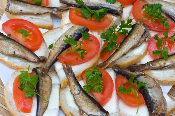 Sandwichs avec sprats sur une assiette — Photo