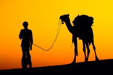 bir adam ve gün batımında deve silüeti
