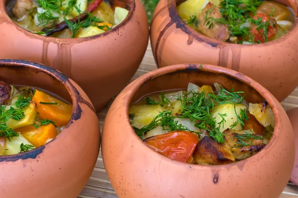 Meat baked with vegetables in rustic clay pot — Stock Photo, Image