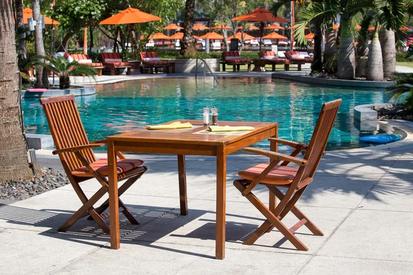 Table and chairs next to the pool, Thailand — Stock Photo, Image