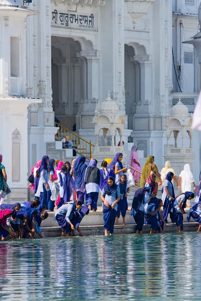 AMRITSAR, INDIA - 18 DE OCTUBRE: Peregrinos sikh en el Templo Dorado durante el día de celebración del 18 de octubre de 2012 en Amritsar, Punjab, India. Harmandir Sahib es el lugar de peregrinación más sagrado para los sijs . —  Fotos de Stock