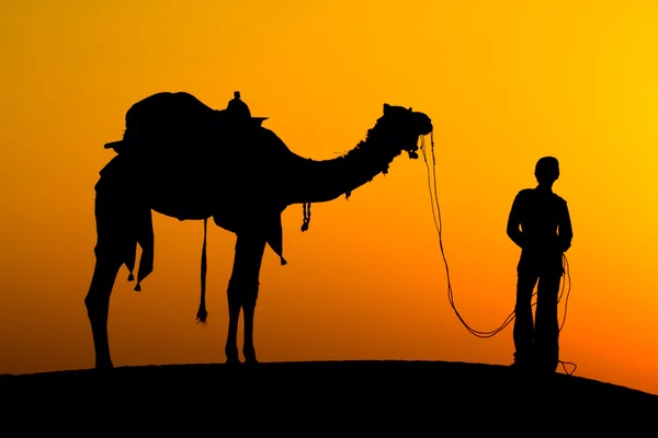 Sylwetka człowieka i wielbłąda na zachód słońca na pustyni, jaisalmer - Indie — Zdjęcie stockowe
