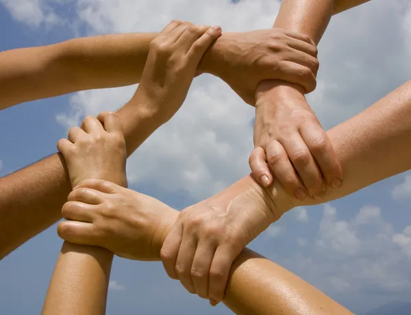 Hands connecting to a chain with blue sky — Stock Photo, Image