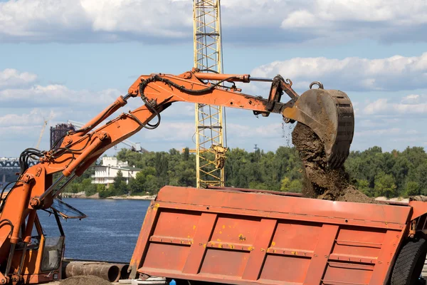 Excavator loading sand on dumper truck — Stock Photo, Image