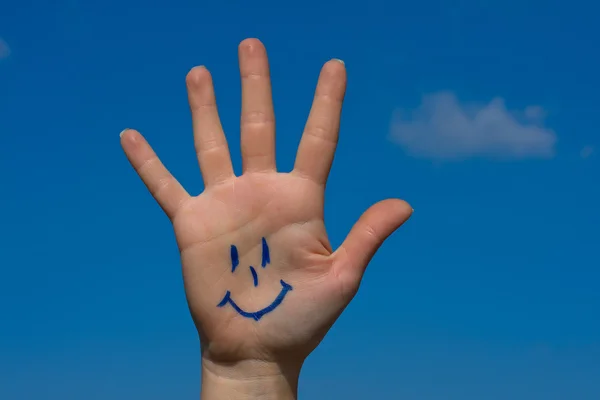 Ανθρώπινη palm με χαμόγελο σε φόντο γαλάζιο του ουρανού — Φωτογραφία Αρχείου
