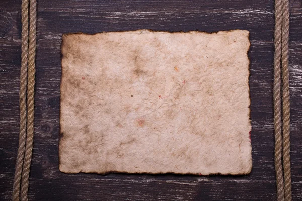 Altes verbranntes Papier auf Holz mit Seilrahmen Hintergrund — Stockfoto