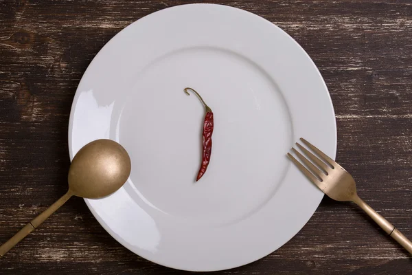 Red pepper on an empty plate — Stock Photo, Image