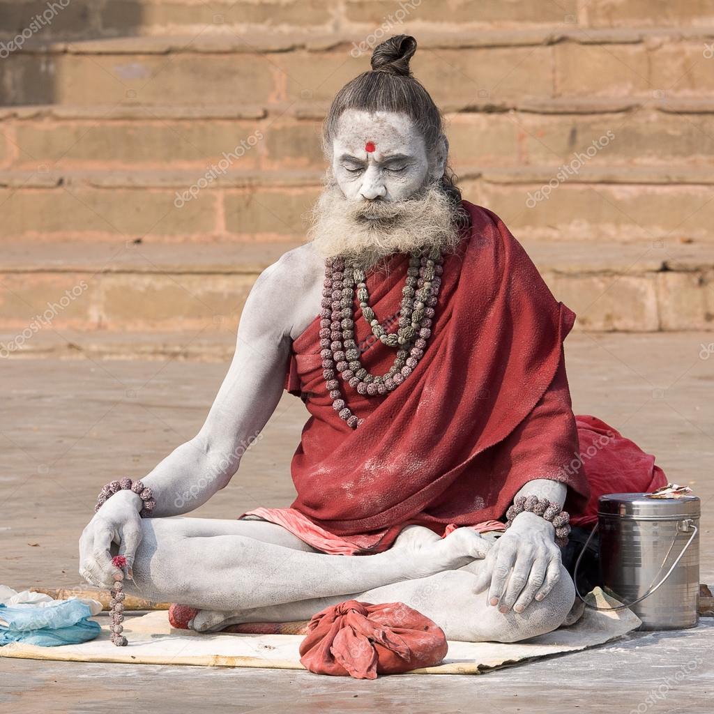 VARANASI, INDIA - DECEMBER 1: An unidentified sadhu sits on the ghat along the Ganges on December 1, 2012 in Varanasi, India. Tourism has drawn many alleged fake sadhus to Varanasi