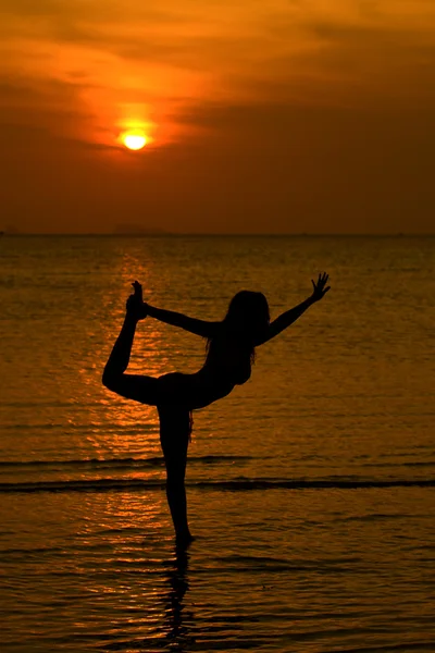 Silueta de mujeres de yoga, trabajando en poses al atardecer —  Fotos de Stock