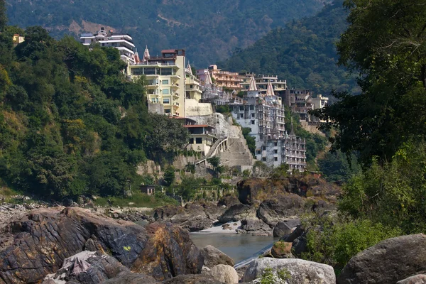 Santo fiume Gange che scorre attraverso Rishikesh (la capitale mondiale dello Yoga) - la città santa per gli indù, India . — Foto Stock