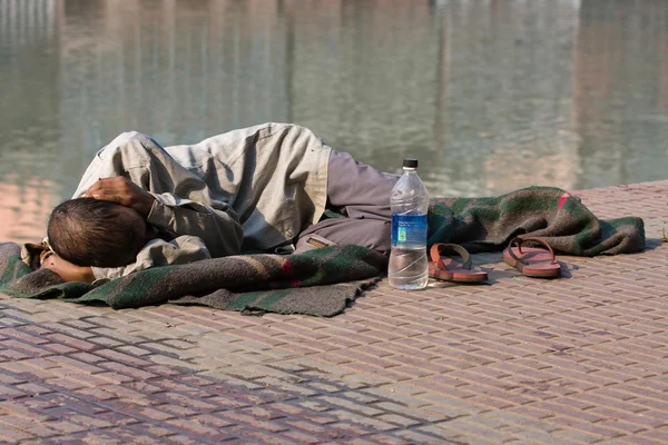 노숙자 남자 리드와 르, 인도에서 강 갠지스 근처 길거리에 자. — 스톡 사진