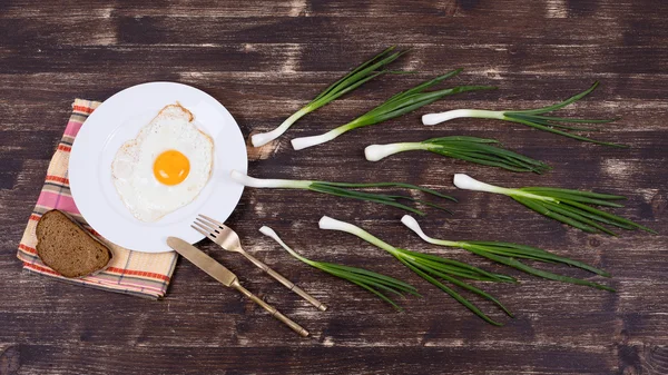 Telur, chives, piring, pisau dan garpu terlihat seperti kompetisi sperma, Spermatozoon mengambang ke ovule — Stok Foto