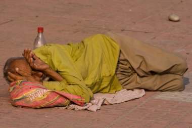 evsiz adam nehir Ganj haridwar, Hindistan'ın yakınlarında kaldırımda yatıyor.