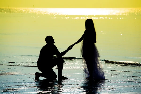 Nygifta på stranden under solnedgången — Stockfoto