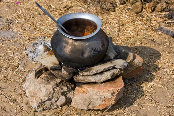Metallgryte med mat i brann, India – stockfoto