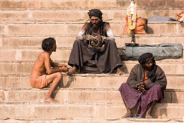 サードゥは、バラナシ、インドのガンジス川沿いのガートに座っています。. — ストック写真