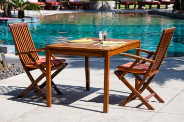 masa ve sandalyeler havuzun yanındaki boş Café