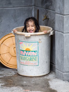  Homeless girl bathes in a plastic bucket, Philippines clipart