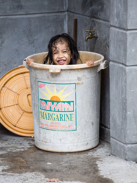  Homeless girl bathes in a plastic bucket, Philippines