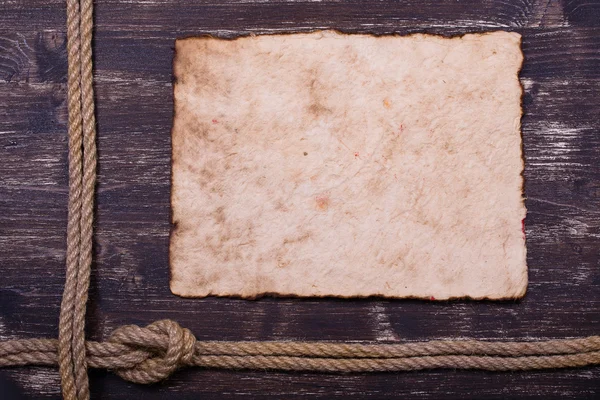 Old burnt paper on wood with rope frame background — Stock Photo, Image