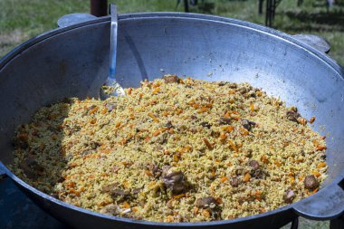 Ukrayna 'daki sokak gıda pazarında büyük bir kazanda geleneksel pilav pişirmek.