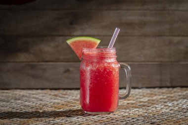 Masadaki cam bardakta taze organik karpuz püresi.