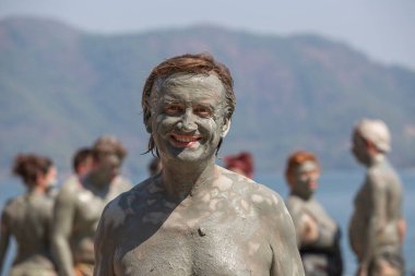 Türkiye, Dalyan 'da çamur tedavisi. Çamur banyosu yapan mutlu adamın portresi.