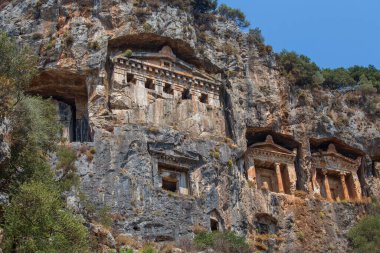 Antik Caunos kasabası Dalyan, Mugla, Türkiye 'nin ünlü Lycian Rock Mezarları. Türkiye 'nin antik mimari harikalarından biri olan Kaunos' taki kaya kesimli tapınak mezarları uçurumlara oyuldu.