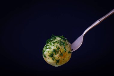 Siyah arka planda haşlanmış taze patatesli çatal. Kapat.