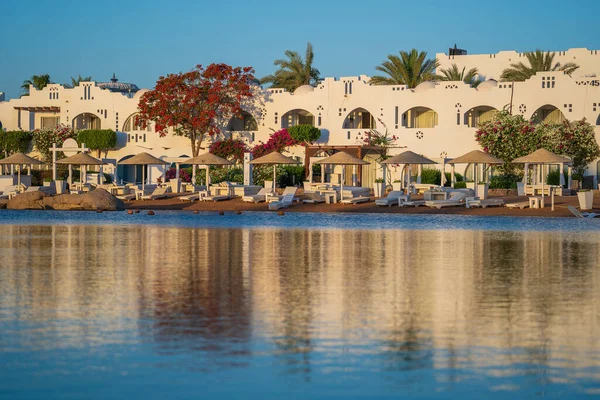 非洲度假胜地沙姆沙伊赫的海滩上平静的红海水反映了建筑物 日光浴者 阳伞和棕榈树 检疫期间的空旷海滩 — 图库照片