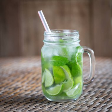 Limon meyve Caipirinha alkollü içecek Brezilya cam kupa üzerinde ahşap masa, yakın çekim