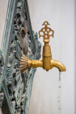 Kentin İstanbul, Türkiye caddesinde içme suyu bulunan kaliteli pirinç musluk, yakın çekim. Duvarda Türk usulü antik çeşme suyu musluğu