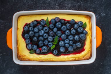 Koyu arkaplanda yabanmersinli cheesecake, üst görünümde, kapat