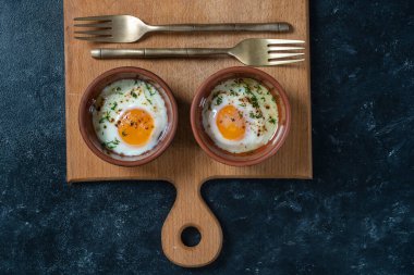Yuvarlak bir seramik tabakta iki yumurta, göz şeklinde. Küçük pişmiş yumurta basit bir kahvaltıdır. Üst görünüm, kapat