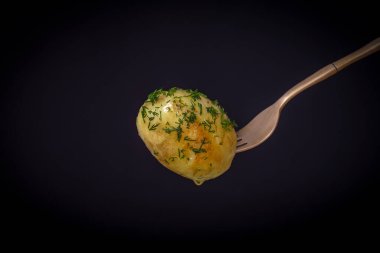 Siyah arka planda haşlanmış taze patatesli çatal. Kapat.