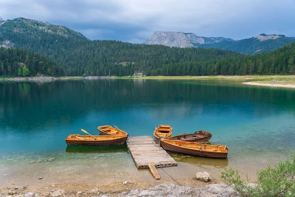 黒湖またはクレノ ジェゼロ モンテネグロ北部の景色 ヨーロッパのザブルジャック近くのデュルモーター国立公園の黒い湖の木製の桟橋近くの観光船 — ストック写真