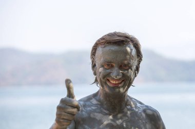 Türkiye, Dalyan 'da çamur tedavisi. Çamur banyosu yapan mutlu adamın portresi.