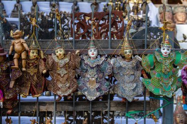 Burma 'daki sokak pazarındaki turist tezgahında renkli kuklalar. Myanmar 'da satılık eşyalar. Vitrinde asılı duran el yapımı bebekler