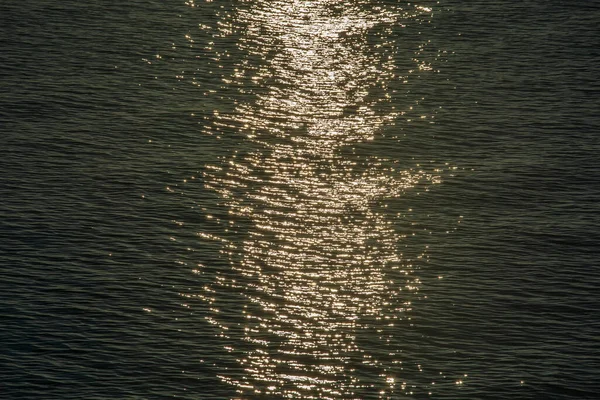 美丽的日落映照在海浪背景的小波纹上闪烁着 尽收眼底 海水的质地 — 图库照片