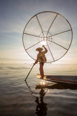 Inle Gölü, Myanmar - 14 Ocak 2016: Bambu teknesinde Burmalı balıkçı el yapımı ağla geleneksel balık yakalıyor. Inle Gölü, Myanmar, Burma