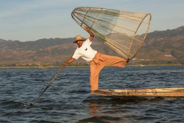 Inle Gölü, Myanmar - 14 Ocak 2016: Bambu teknesinde Burmalı balıkçı el yapımı ağla geleneksel balık yakalıyor. Inle Gölü, Myanmar, Burma