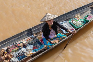 Inle Gölü, Myanmar - 14 Ocak 2016: Birmanyalı kadın küçük tahta bir teknede hediyelik eşya, incik boncuk ve bijouterieat the floater market, Inle Lake, Myanmar