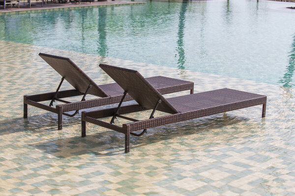 Deck chairs in the swimming pool at a tropical resort near sea in Burma, Myanmar. Close up