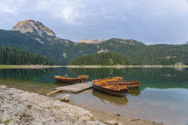 黒湖またはクレノ ジェゼロ モンテネグロ北部の景色 ヨーロッパのザブルジャック近くのデュルモーター国立公園の黒い湖の木製の桟橋近くの観光船 — ストック写真