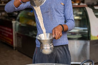 Hindistan, Pushkar 'daki dükkanında müşteriler için sıcak sütlü çay ya da çay koyun. Kapatın.