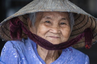 Nha Trang, Vietnam - 30 Mart 2020 Nha Trang, Vietnam 'da bir sokak pazarında saman şapkalı mutlu yaşlı kadın