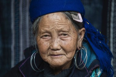 Sapa, Vietnam - Mart 02, 2020: Geleneksel kıyafet ve mücevher giyen etnik Hmong kadını Turistlerin Sapa, Kuzey Vietnam 'daki dağ köyünde el sanatları satmalarını bekliyor