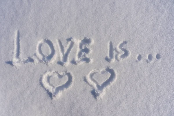 2つの心の形とテキストの愛は 冬には白い新鮮な雪の上に クローズアップされます ロマンスの形の挨拶として冬の愛のシンボル コピースペースの背景 — ストック写真