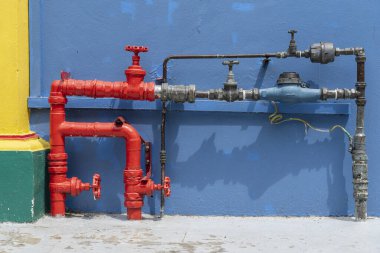 Bir şehir caddesinde kırmızı yangın boruları , Singapur . Sıhhi tesisat su boruları mavi duvara yakın, açık havada