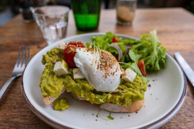 Ekşi ekmek, haşlanmış yumurta, avokado hamuru ve kafede taze sebzeler, kapanış, kahvaltı zamanı.